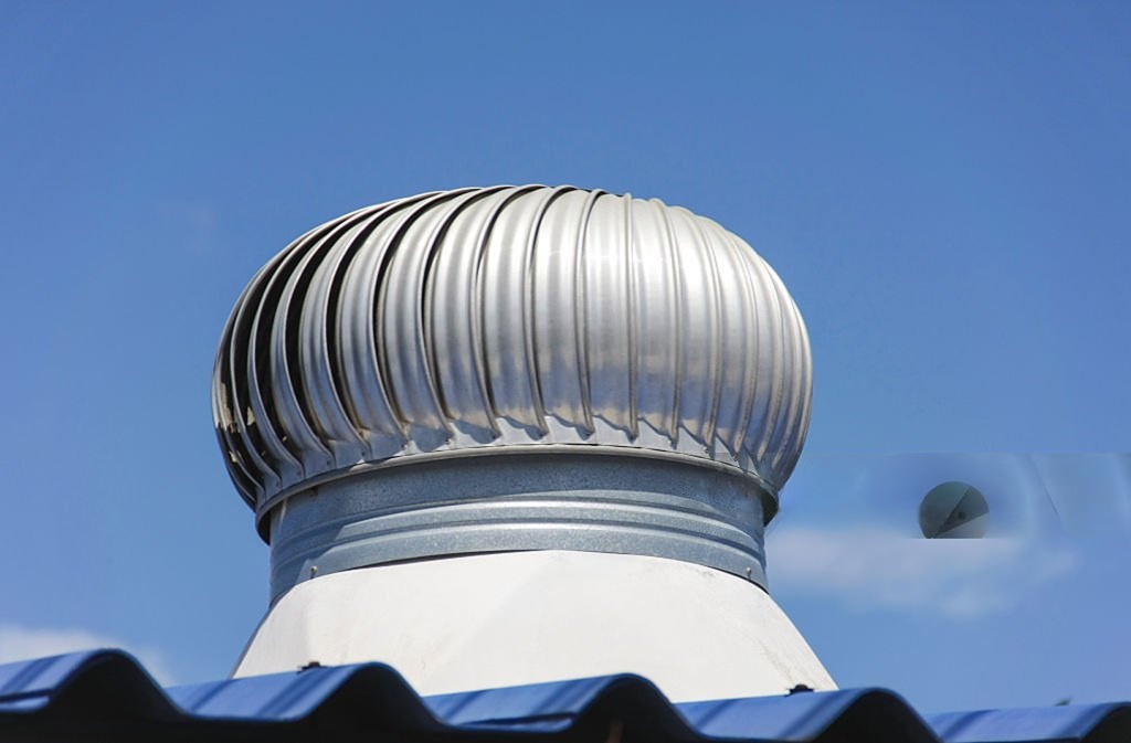 Turbine ventilator di atap dengan langit biru cerah